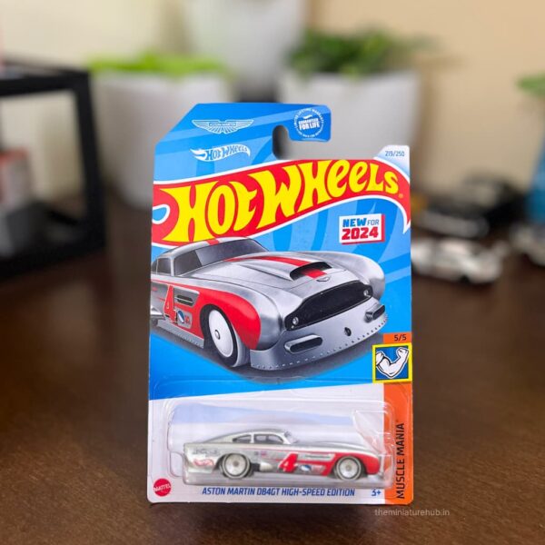 Imported Hot Wheels Aston Martin DB4GT High-Speed Edition Muscle Mania USA Card die-cast model in ZAMAC with red racing accents.