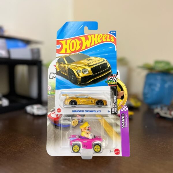 Hot Wheels Pack of 2 featuring Mario Kart Wario Badwagon and 2018 Bentley Continental GT3 with a free collectible gift (may be a keychain). Authentic diecast set from The Miniature Hub.